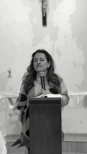 Georgia Moura em palestra, no púlpito, com microfone.